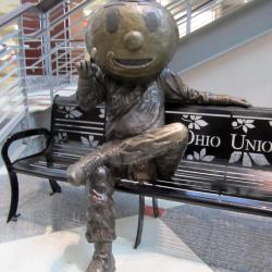 front view of copper Brutus statue sitting on bench